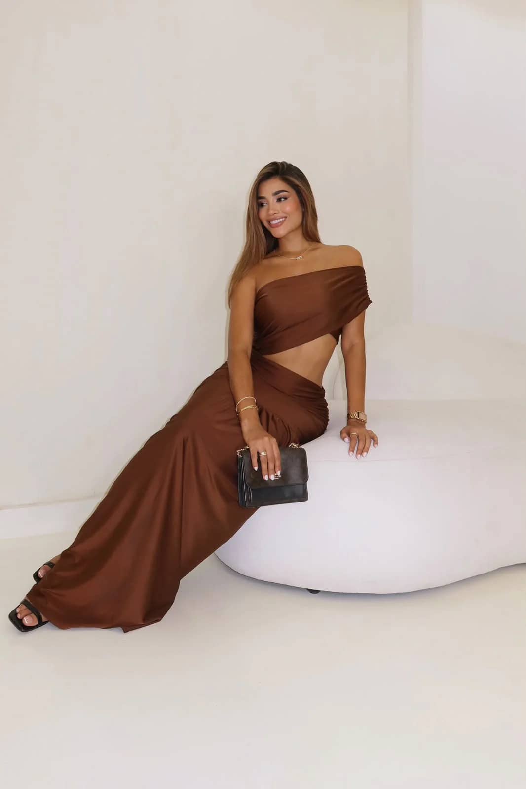 Vestido Fantasía café con falda maxi fruncida, modelo sentada sonriendo
